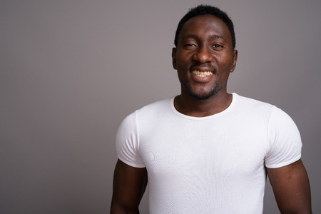 Young handsome African man against gray backgroundの写真素材