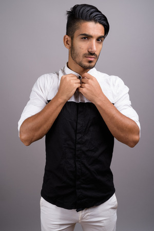 Young handsome Persian businessman against gray backgroundの写真素材