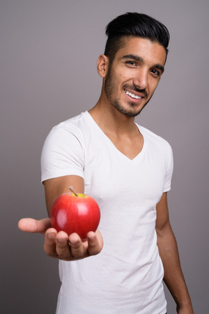 Young handsome Persian man against gray backgroundの写真素材