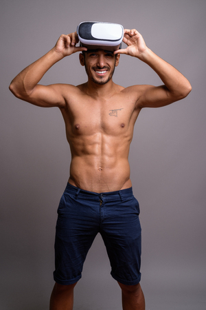 Young handsome Persian man shirtless against gray backgroundの写真素材