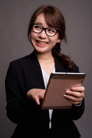 Young beautiful Asian businesswoman using digital tabletの写真素材