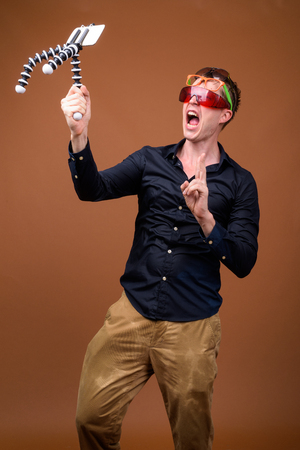 Young man influencer in wet clothes vlogging with mobile phoneの写真素材