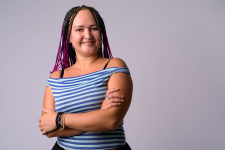 Portrait of happy rebellious woman smiling with arms crossedの写真素材