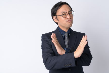 Portrait of Japanese businessman in suit showing stop gestureの写真素材