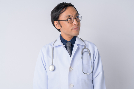Portrait of Japanese man doctor thinking and looking upの写真素材
