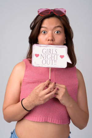 Young surprised Asian woman with heart shaped glasses ready for girls night outの写真素材