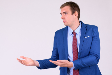 Portrait of businessman in suit thinking and showing somethingの写真素材