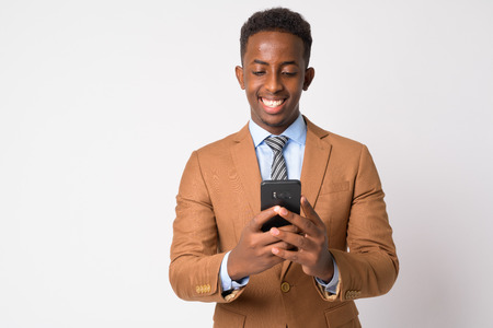 Portrait of young happy African businessman using phone