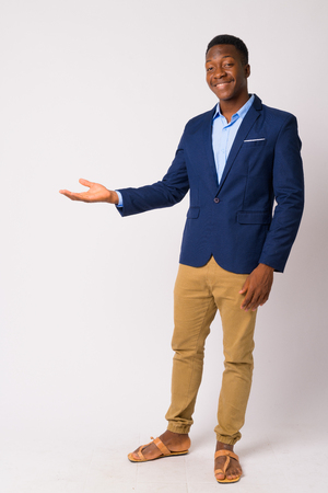 Full body shot of young happy African businessman showing somethingの写真素材