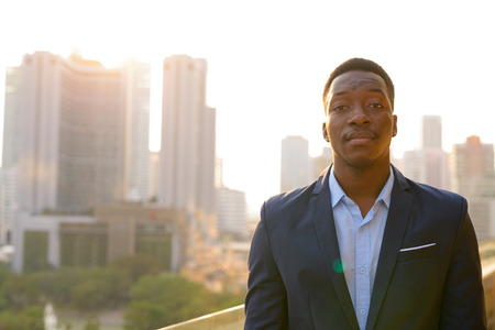Young handsome African businessman against view of the city