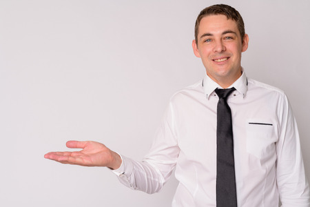 Portrait of happy handsome businessman showing somethingの写真素材
