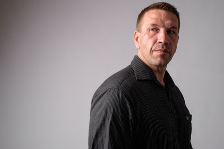 Portrait of macho mature businessman thinking and looking back