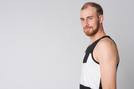 Profile view of young bearded man looking at cameraの写真素材