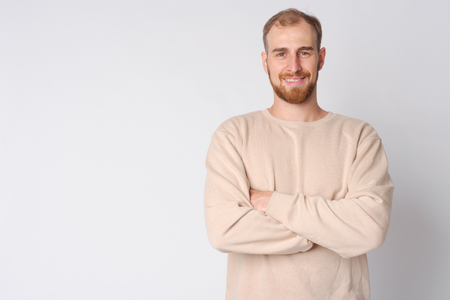 Portrait of happy young bearded man smiling with arms crossedの写真素材