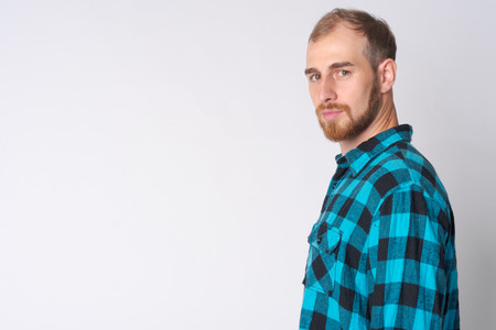 Profile view of young bearded hipster man looking at cameraの写真素材