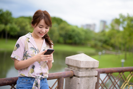 Young beautiful Asian tourist woman relaxing at the parkの写真素材