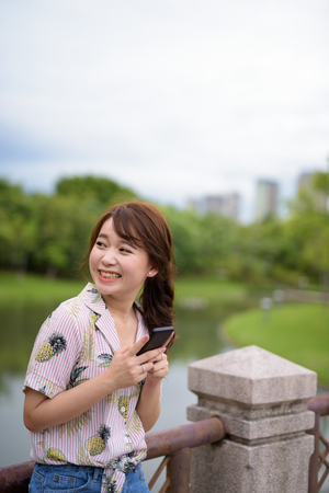 Young beautiful Asian tourist woman relaxing at the parkの写真素材