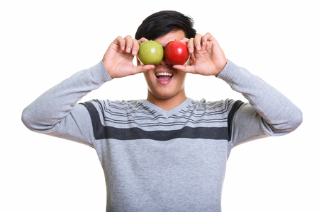 Studio shot of happy Asian man smiling while covering eyes withの写真素材