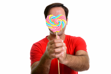 Studio shot of young Persian man covering face with delicious heの写真素材