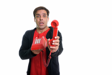 Studio shot of young Persian man looking shocked while giving olの写真素材