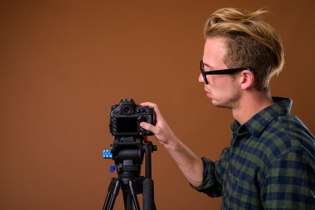 Studio shot of young handsome man against brown background