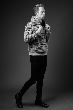 Studio shot of young handsome man against gray background in blaの写真素材