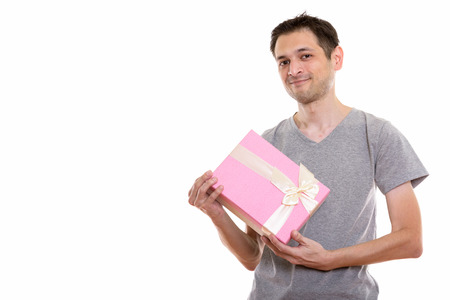 Studio shot of young man holding gift box ready for Valentinesの写真素材
