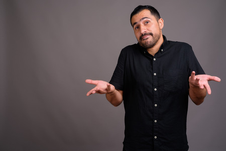 Handsome bearded Persian man against gray backgroundの写真素材