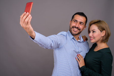 Multi-ethnic couple in love against gray backgroundの写真素材
