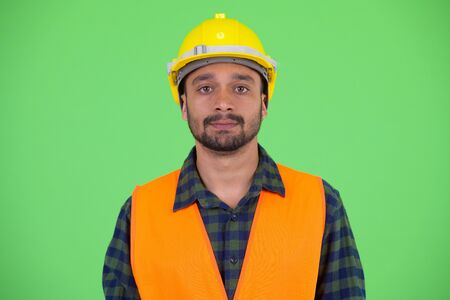 Face of young bearded Persian man construction workerの写真素材