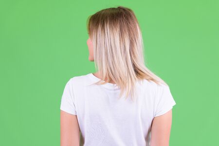 Rear view of young blonde woman looking over shoulder