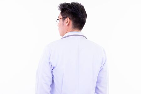 Rear view of young Asian man doctor looking over shoulderの写真素材