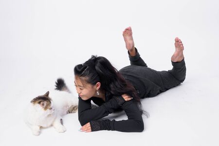 Full body shot of beautiful Asian woman lying down with Persian catの写真素材