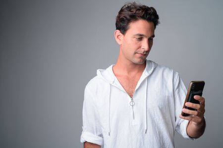 Portrait of handsome Hispanic man using phoneの写真素材