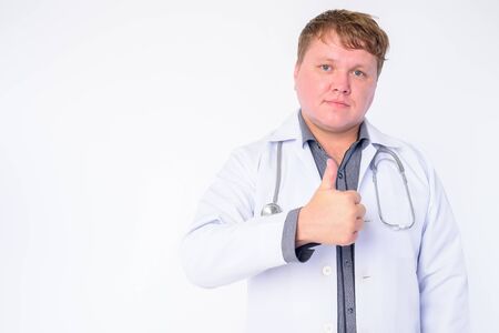 Portrait of overweight man doctor giving thumbs upの写真素材