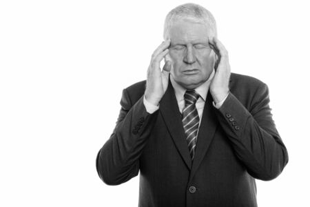 Studio shot of stressed mature businessman having headache