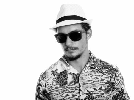Studio shot of young handsome tourist man wearing sunglasses isolated against white backgroundの写真素材