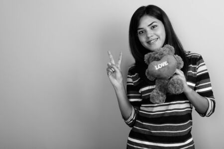 Young beautiful Indian woman against gray backgroundの写真素材