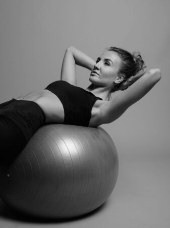 Young beautiful woman ready for gym against gray backgroundの写真素材