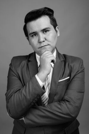 Young multi ethnic businessman against gray backgroundの写真素材