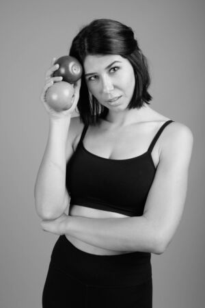 Young beautiful woman ready for gym against gray backgroundの写真素材