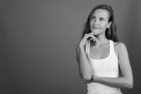 Young beautiful woman thinking and looking up shot in black and whiteの写真素材