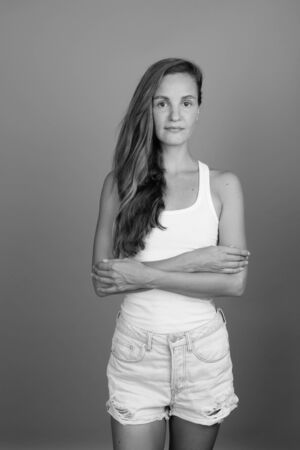 Young beautiful woman with long blond hair against gray backgroundの写真素材