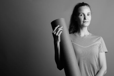 Young beautiful woman holding exercise mat for yoga trainingの写真素材