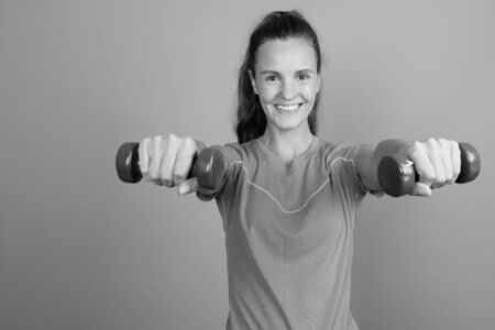 Young beautiful woman holding dumbbells ready for exerciseの写真素材