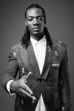 Young handsome African businessman against brown backgroundの写真素材