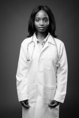Young beautiful African Zulu woman doctor against brown backgroundの写真素材