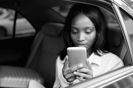 Young beautiful African Zulu businesswoman riding inside the car