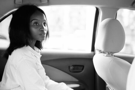 Young beautiful African Zulu businesswoman riding inside the car