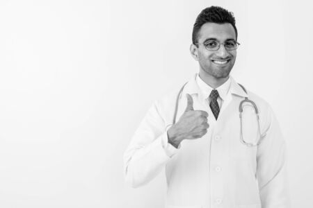 Young handsome Indian man doctor against white backgroundの写真素材